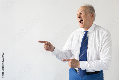 Photos Portrait of excited mature businessman showing something