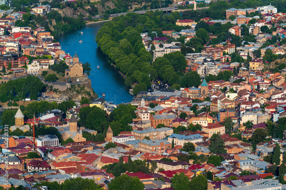 Aerial view of Tbilisi Old Town cityscape with ancient houses,  trees and  Kura river, Georgia, Europe