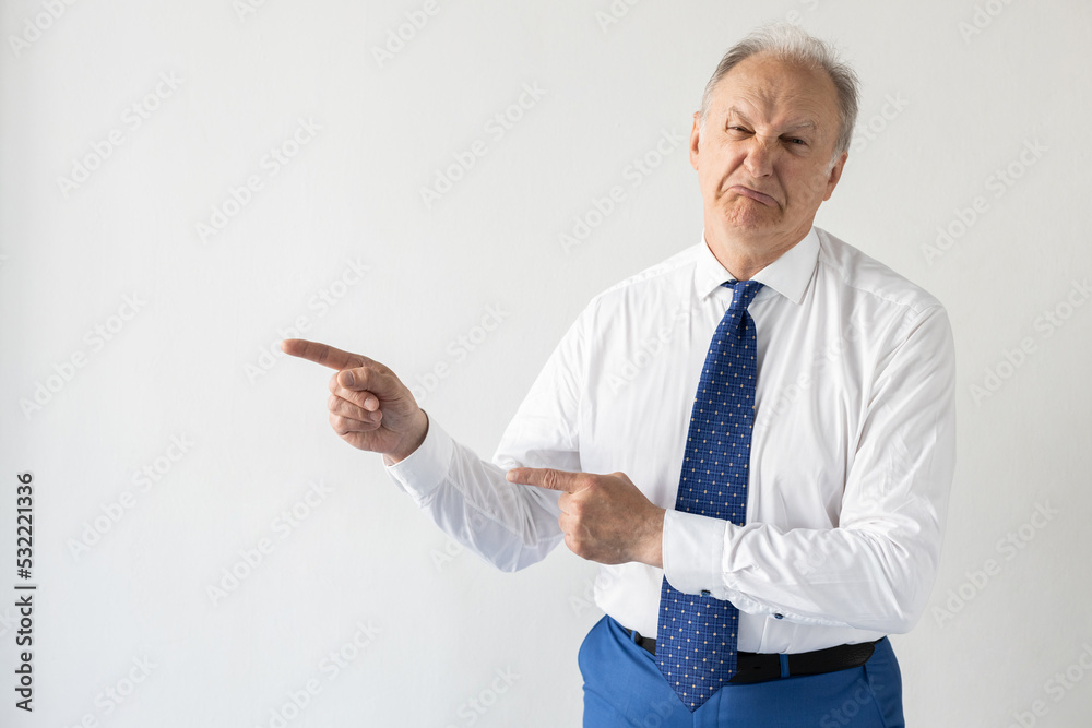 Portrait of mature businessman showing something with disgust. Senior man wearing formalwear looking at camera and frowning against white background. Disgust concept Portrait of mature businessman showing something with disgust. Senior man wearing formalwear looking at camera and frowning against white background. Disgust concept