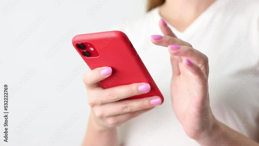 woman swiping red smartphone close-up woman swiping red smartphone close-up