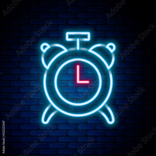 Glowing neon line Alarm clock icon isolated on brick wall background. Wake up, get up concept. Time sign. Colorful outline concept. Vector