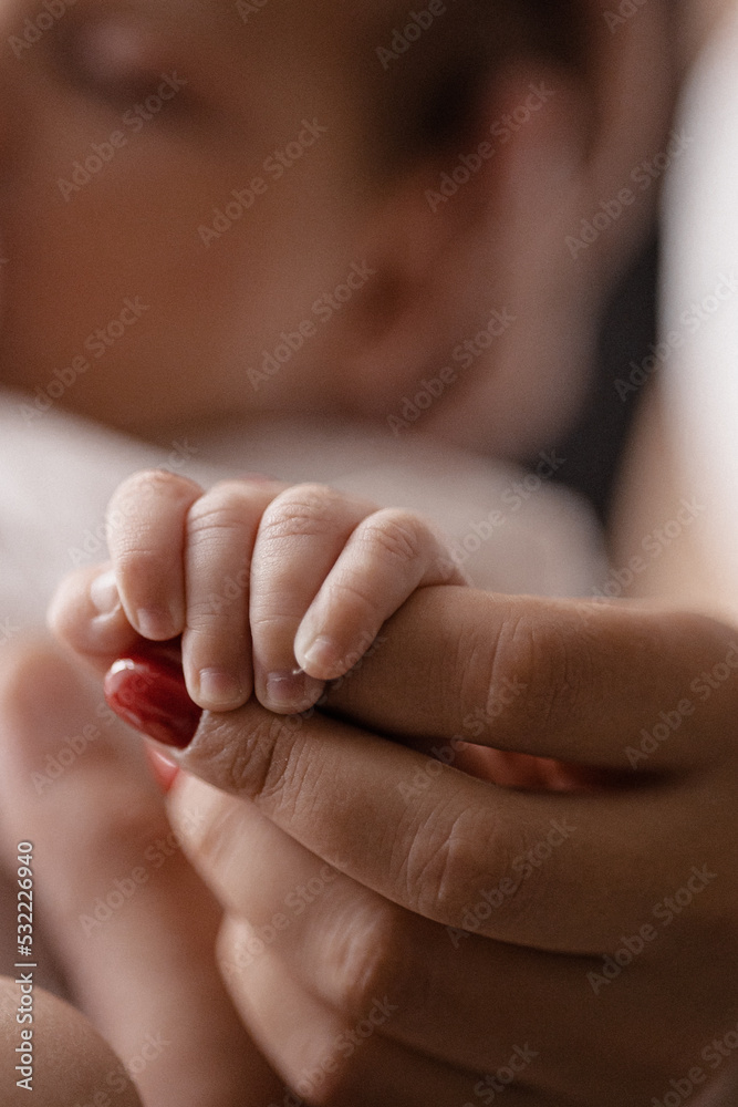 New born baby hand hold mum index finger. Mother and baby.