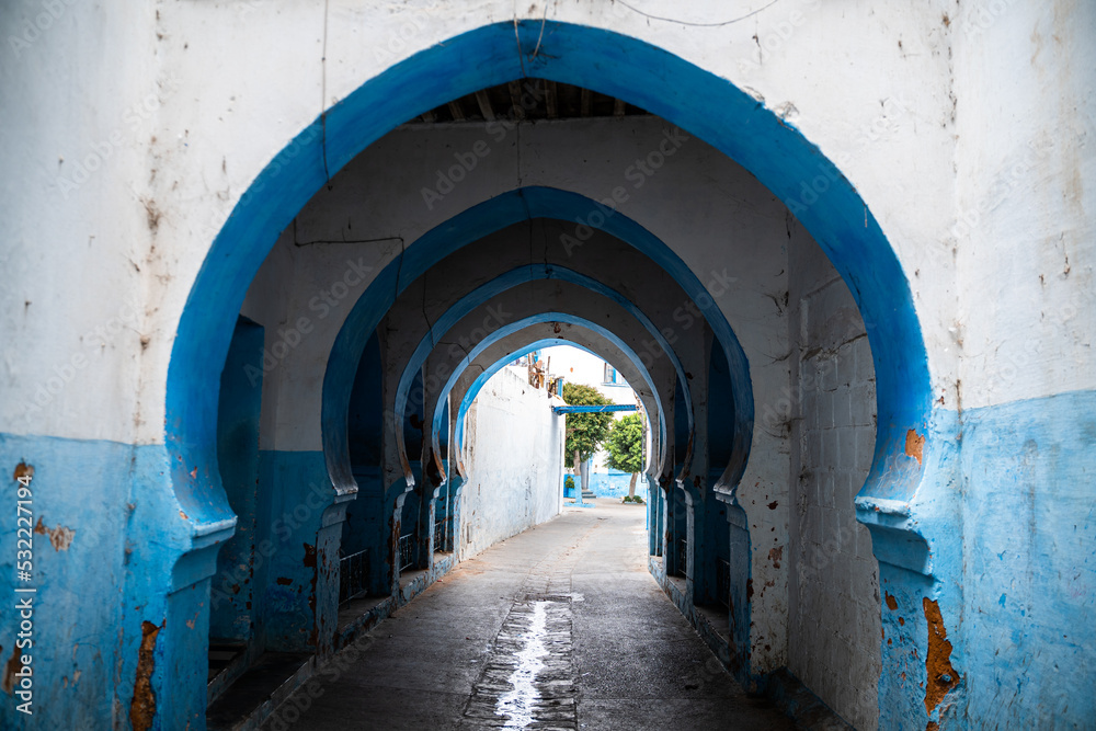 Callejuela en Marruecos con arcos azul y blanco.