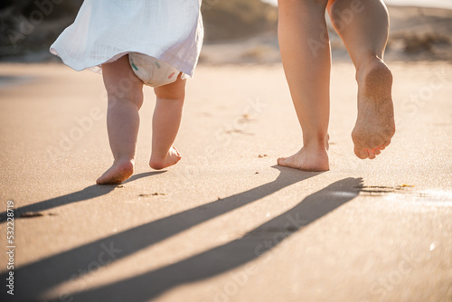 Madre e hija caminando por la playa 