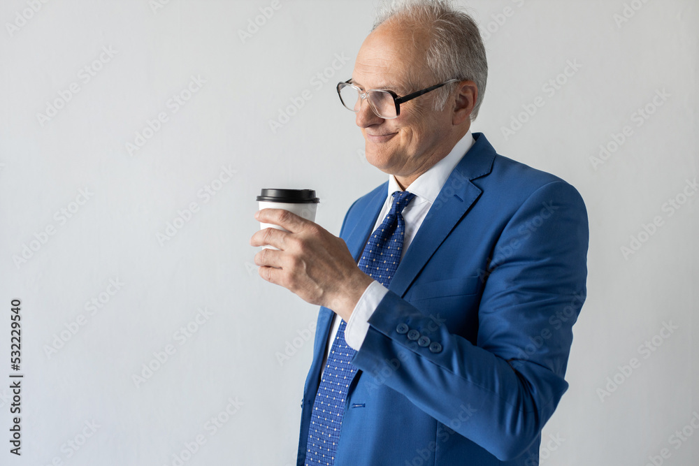 Portrait of happy mature businessman drinking coffee. Senior manager wearing formalwear and eyeglasses standing with takeout drink and smiling against white background. Coffee break concept Portrait of happy mature businessman drinking coffee. Senior manager wearing formalwear and eyeglasses standing with takeout drink and smiling against white background. Coffee break concept