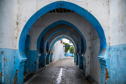 Callejuela de Larache en Marruecos de arcos azules y blancos.