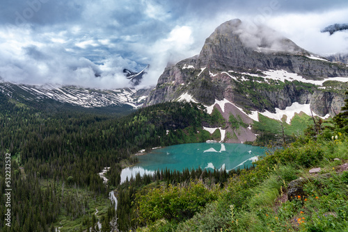 Grinnell Lake in Glacier National Park on a cloudy summer day, with dramatic clouds