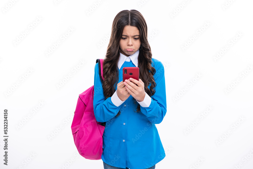 Smartphone and school child. Student girl with phone on isolated background. Angry teenager girl, upset and unhappy negative emotion. Smartphone and school child. Student girl with phone on isolated background. Angry teenager girl, upset and unhappy negative emotion.
