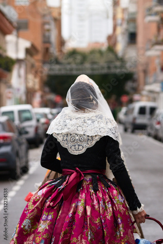 Full body image of a fallera dressed in the typical costume of the Valencian Fallas, Spain photo