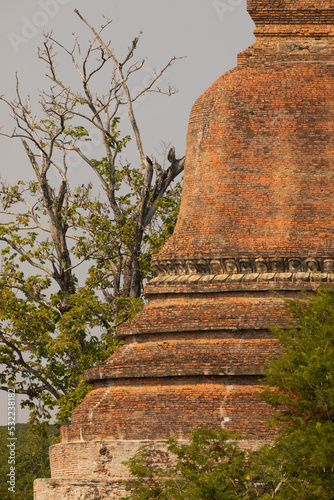 Huge pagoda built with bricks  surrounded by vegetation  in Sukothai  Thailand