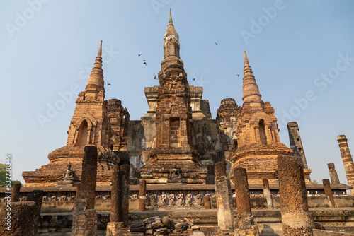 Wat Mahathat temple and pagodas of Thai style architecture and trees, in Sukhothai Historical Park at sunset