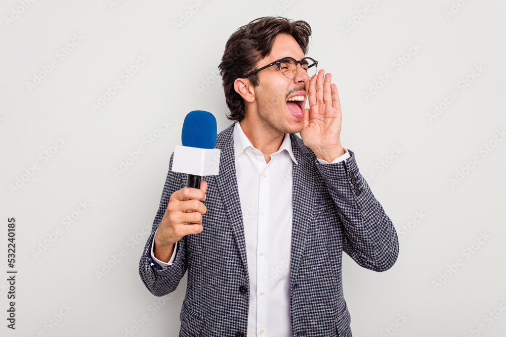 Young hispanic TV presenter man isolated on white background shouting and holding palm near opened mouth. - obrazy, fototapety, plakaty 