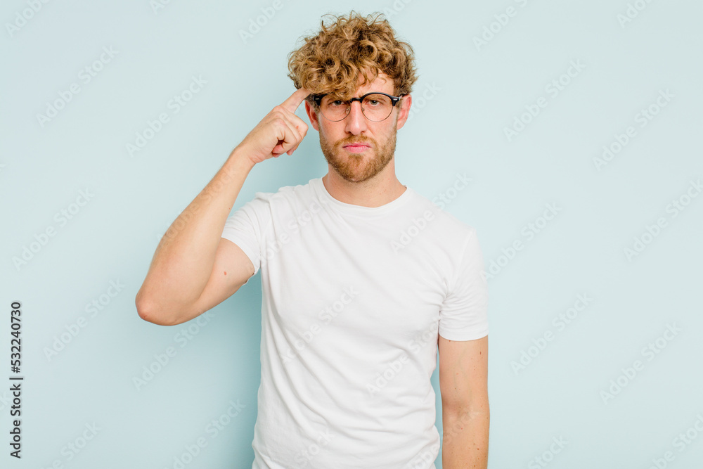 Young caucasian man isolated on blue background pointing temple with finger, thinking, focused on a task. Young caucasian man isolated on blue background pointing temple with finger, thinking, focused on a task.