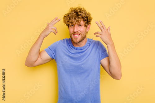 Young caucasian man isolated on yellow background showing a disappointment gesture with forefinger.