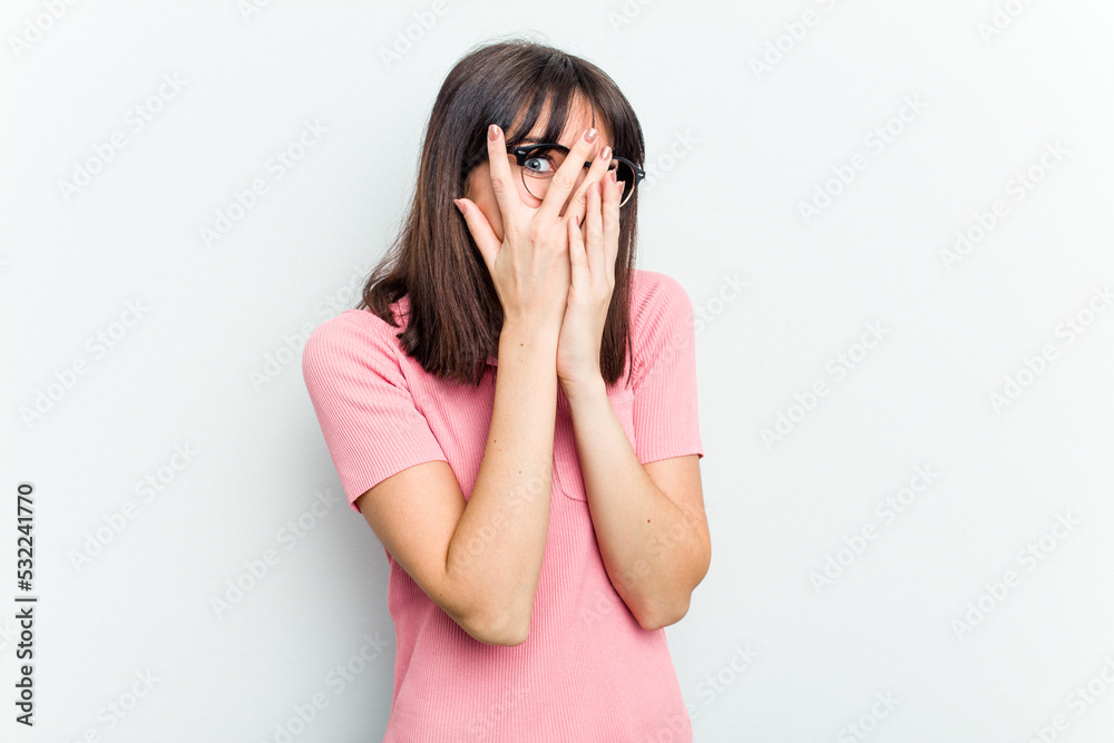 Young caucasian woman isolated on white background blink through fingers frightened and nervous. Young caucasian woman isolated on white background blink through fingers frightened and nervous.