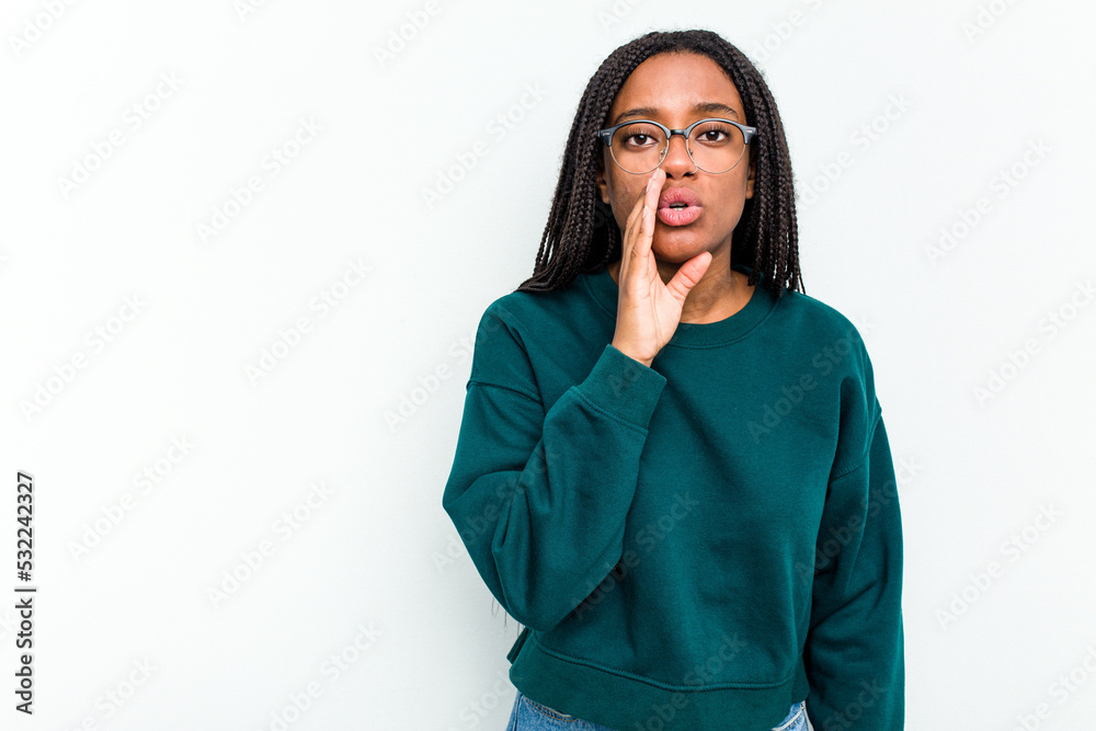 Young African American woman isolated on white background is saying a secret hot braking news and looking aside Young African American woman isolated on white background is saying a secret hot braking news and looking aside