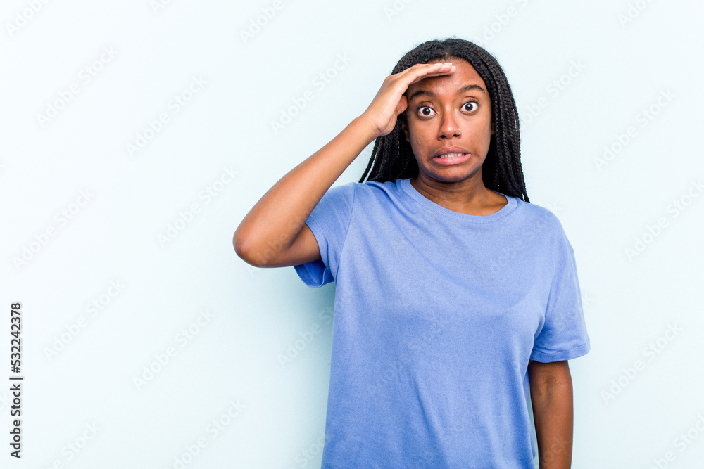Young African American woman with braids hair isolated on blue background shouts loud, keeps eyes opened and hands tense. Young African American woman with braids hair isolated on blue background shouts loud, keeps eyes opened and hands tense.