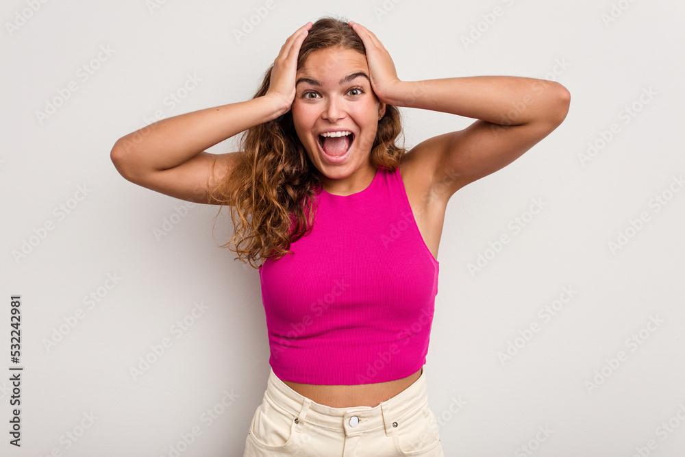 Young caucasian woman isolated on blue background screaming, very excited, passionate, satisfied with something. Young caucasian woman isolated on blue background screaming, very excited, passionate, satisfied with something.