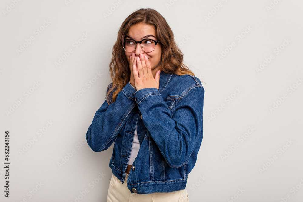 Young caucasian woman isolated on blue background laughing about something, covering mouth with hands.