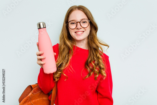 фотографія Young student woman holding a canteen isolated on blue background happy, smiling and cheerful