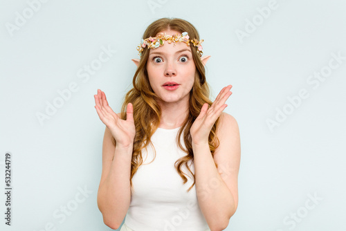 Young elf woman isolated on blue background surprised and shocked.