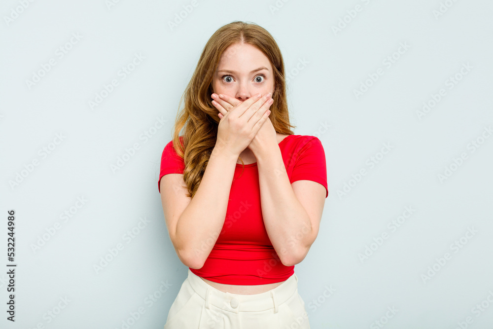 Young caucasian woman isolated on blue background shocked covering mouth with hands. Young caucasian woman isolated on blue background shocked covering mouth with hands.
