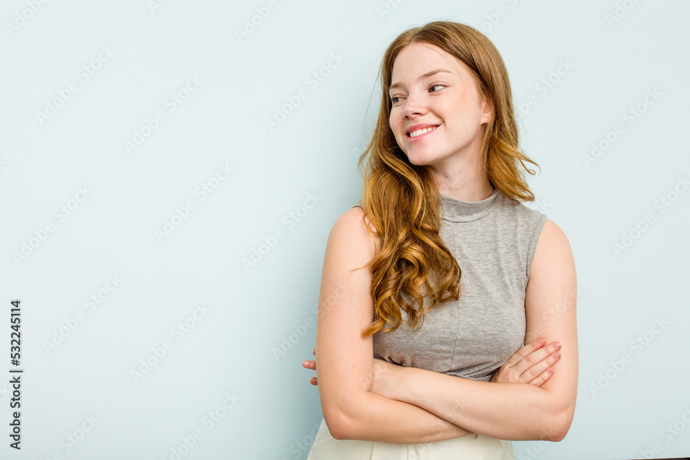 Young caucasian woman isolated on blue background smiling confident with crossed arms. Young caucasian woman isolated on blue background smiling confident with crossed arms.