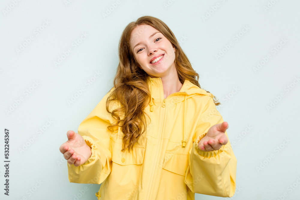 Young caucasian woman isolated on blue background showing a welcome expression. Young caucasian woman isolated on blue background showing a welcome expression.