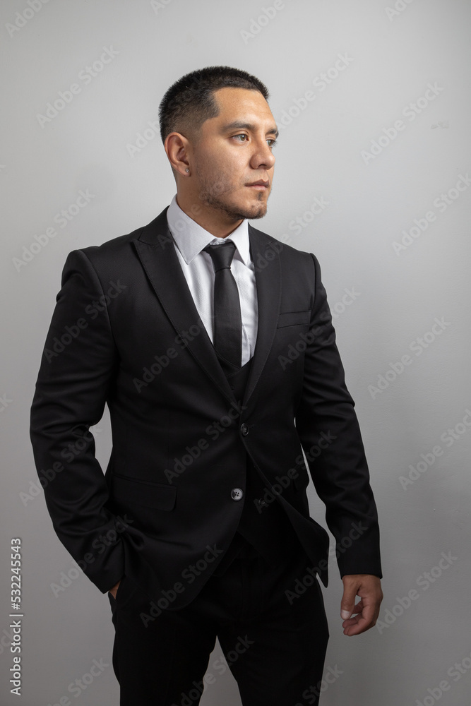 elegant latin young man with short hair and beard, business clothes, suit, shirt and tie, fashion and lifestyle in studio elegant latin young man with short hair and beard, business clothes, suit, shirt and tie, fashion and lifestyle in studio