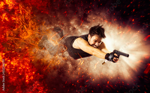 Excited man holding gun. Fire background © Andrey Burmakin