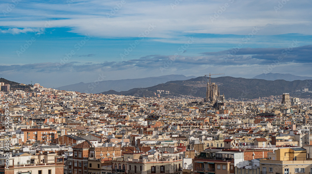 Cityscape of Barcelona with blue sky and mountains on background. Vacation and travel concept 