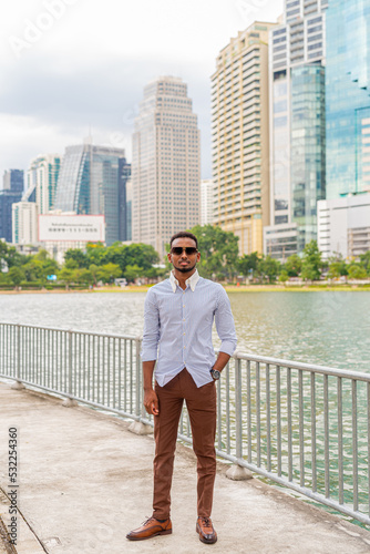 Handsome young black businessman at park outdoors during summer