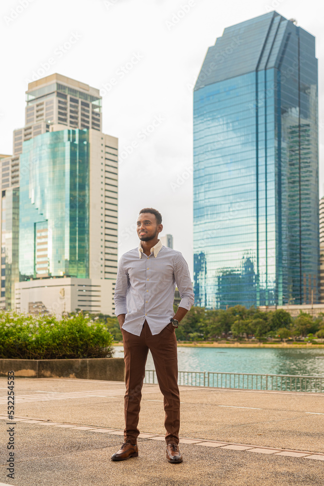 Handsome young black businessman at park outdoors during summer Handsome young black businessman at park outdoors during summer