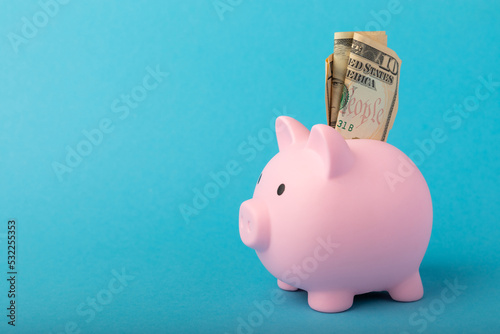 Piggy bank on a blue background.Piggy bank with dollar bills.The concept of investment and saving money.Investments.Place of milking text. Place to copy. mockup