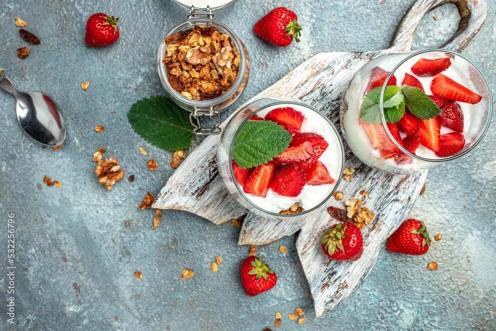 Parfait with yogurt, granola, jam, fresh berries and mint leaves in glass jar. gluten free diet, Healthy breakfast. banner, menu, recipe place for text