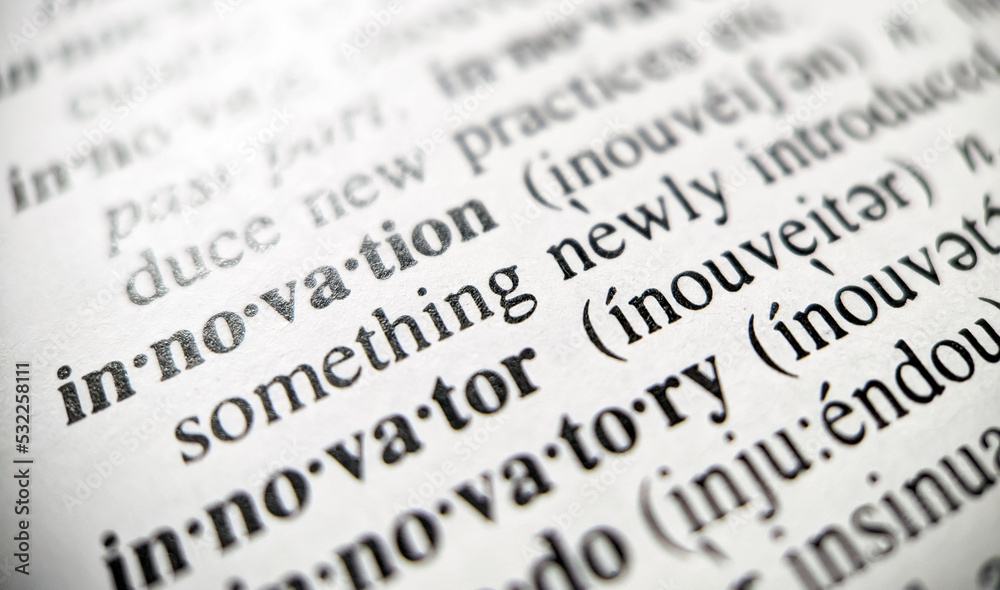Fototapeta premium Innovation dictionary definition with closeup view of text on book paper with focus blur