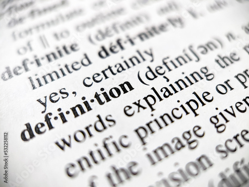 Dictionary definition word defined on paper page with focus blur