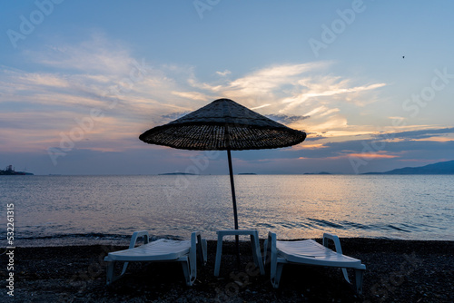 beach chairs and umbrellas at sunset