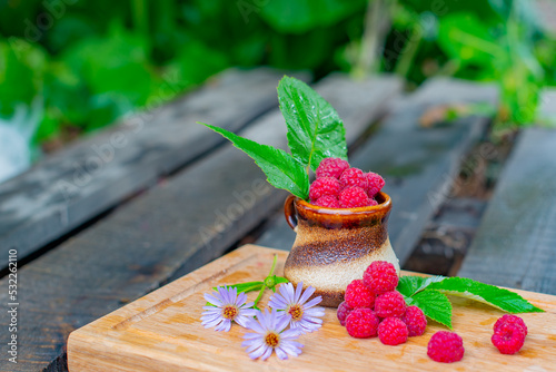 raspberries in a glass and a handful of raspberries and flowers of the Novobelgian Aster. High quality photo photo