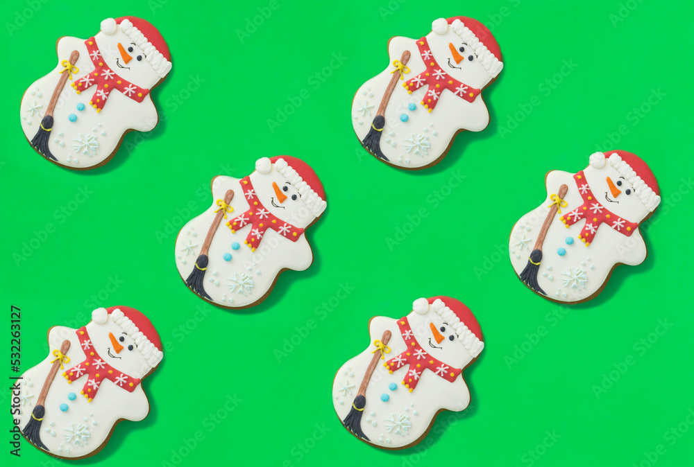 Christmas gingerbread in the shape of a snowman on the green background. Top view. Christmas gingerbread in the shape of a snowman on the green background. Top view.