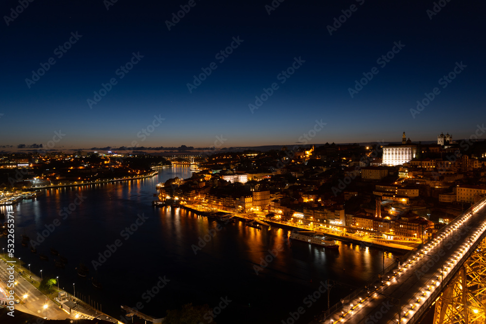 Sunset view of the city of Porto, the sunset is reflected in the river, view of the illuminated city.