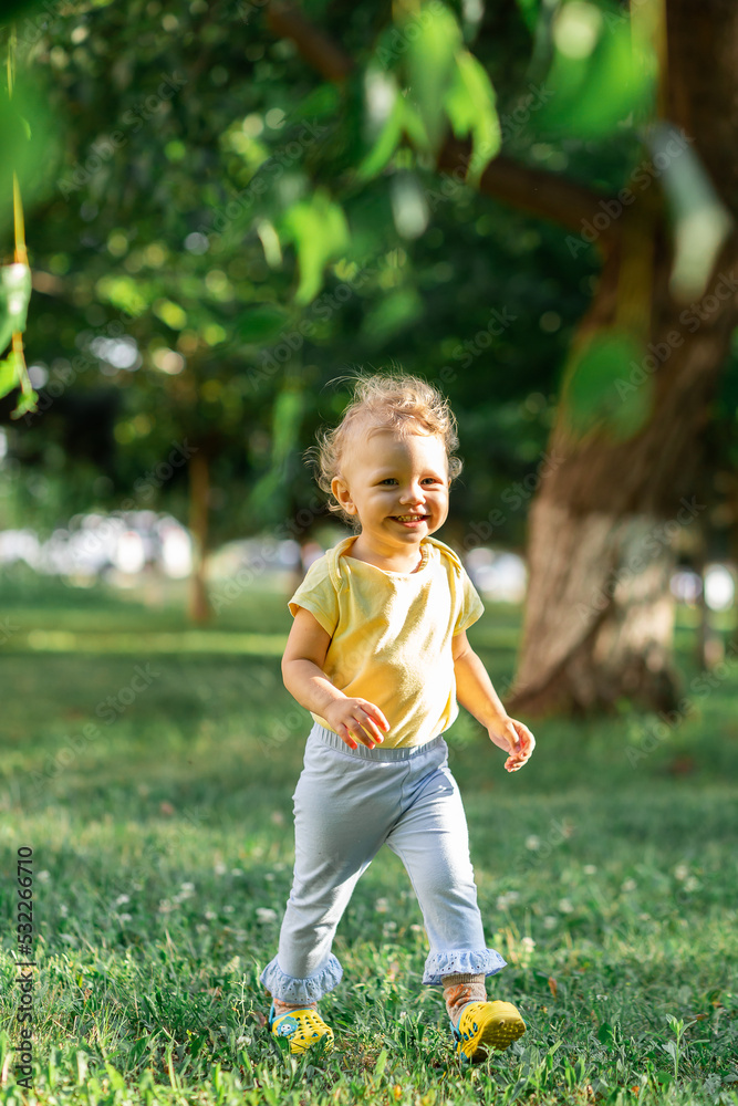 Blurred curly girl in motion running on a blurred green background. Blurred curly girl in motion running on a blurred green background.