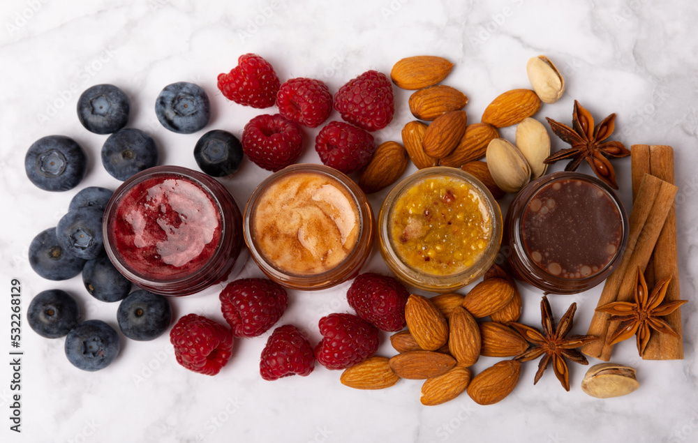 Jar of honey. Fruit honey with raspberries, blueberries, almonds and pistachios. Jams for health and beauty. Honey cream. Organic product of a vegetarian diet. Copy space.Copy space. Jar of honey. Fruit honey with raspberries, blueberries, almonds and pistachios. Jams for health and beauty. Honey cream. Organic product of a vegetarian diet. Copy space.Copy space.