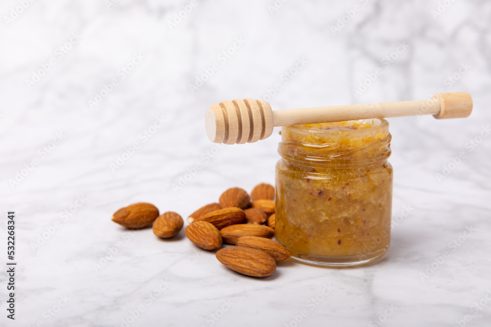 Nut honey jar on white wood. Cold medicine. Useful fortified product with almonds, pistachios, star anise and cinnamon for health and beauty. Vegetarian diet organic product. Copy space.place for text Nut honey jar on white wood. Cold medicine. Useful fortified product with almonds, pistachios, star anise and cinnamon for health and beauty. Vegetarian diet organic product. Copy space.place for text
