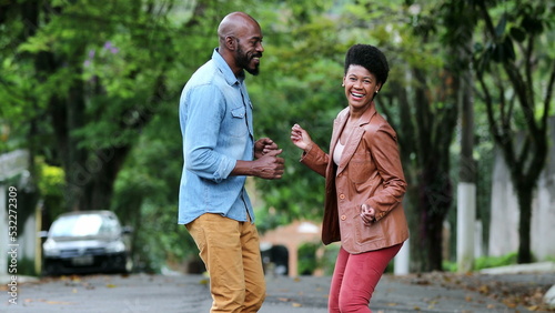 African man and woman dancing in celebration. People celebrating success in street