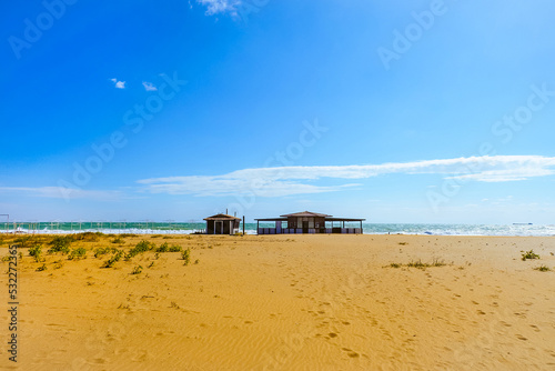 Beach cafe on the deserted sunny sandy coast of the Black Sea. Empty beach in autumn season. © nskyr2