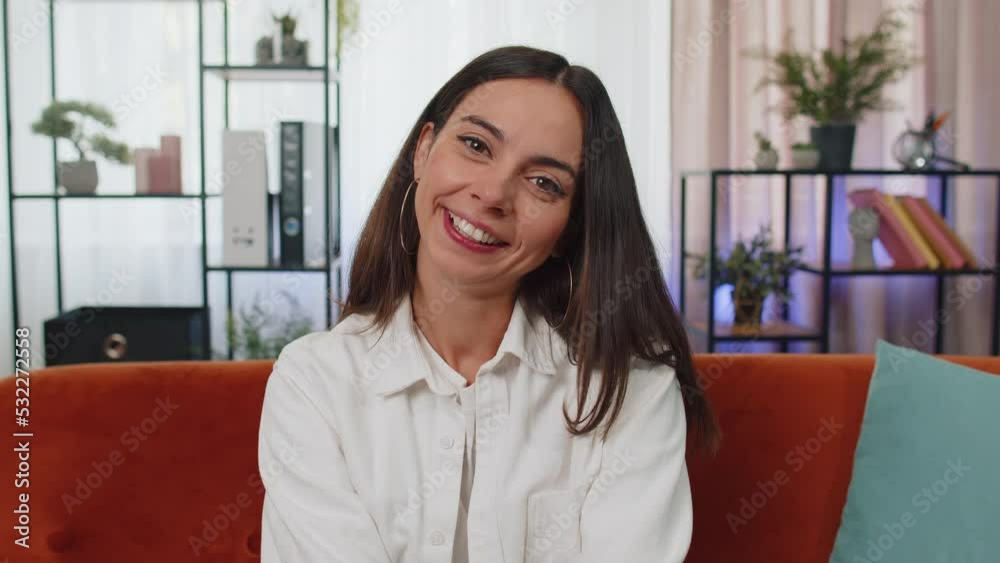 Close-up portrait of happy smiling caucasian girl in shirt, looking at camera, celebrate good news. Young woman indoor isolated at home in living room sitting on orange couch. Female nature beauty Close-up portrait of happy smiling caucasian girl in shirt, looking at camera, celebrate good news. Young woman indoor isolated at home in living room sitting on orange couch. Female nature beauty