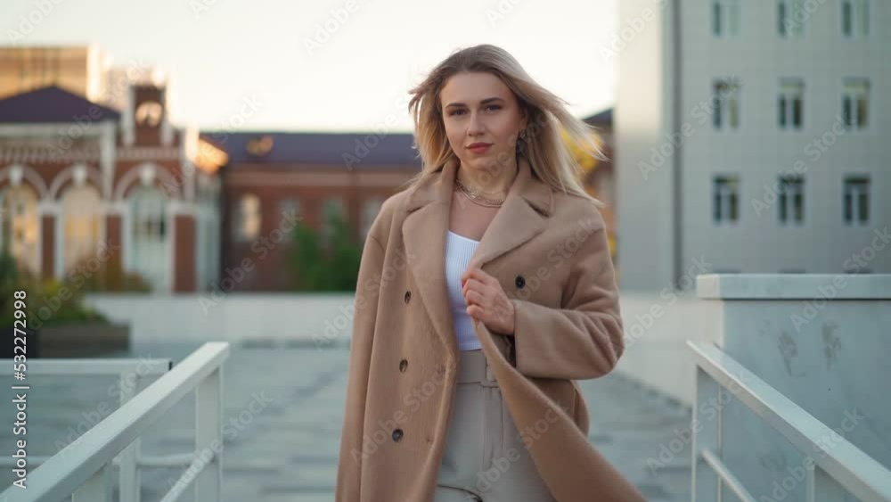 Portrait, Attractive Business Woman Looking Confident in a Brown Coat is Walking along a City Street. Career People. Fashion, Beauty. Female Portraits. Real People. Slow Motion Portrait, Attractive Business Woman Looking Confident in a Brown Coat is Walking along a City Street. Career People. Fashion, Beauty. Female Portraits. Real People. Slow Motion