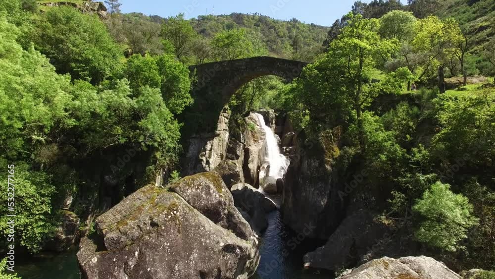 Nature Landscape. Medieval Bridge on Mountain Rocks with River and Waterfalll in the Background Surrounded by Green Forest. Environment Concept. Misarela Bridge, Portugal