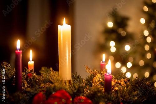 Christmas candles on an advent wreath in dark church